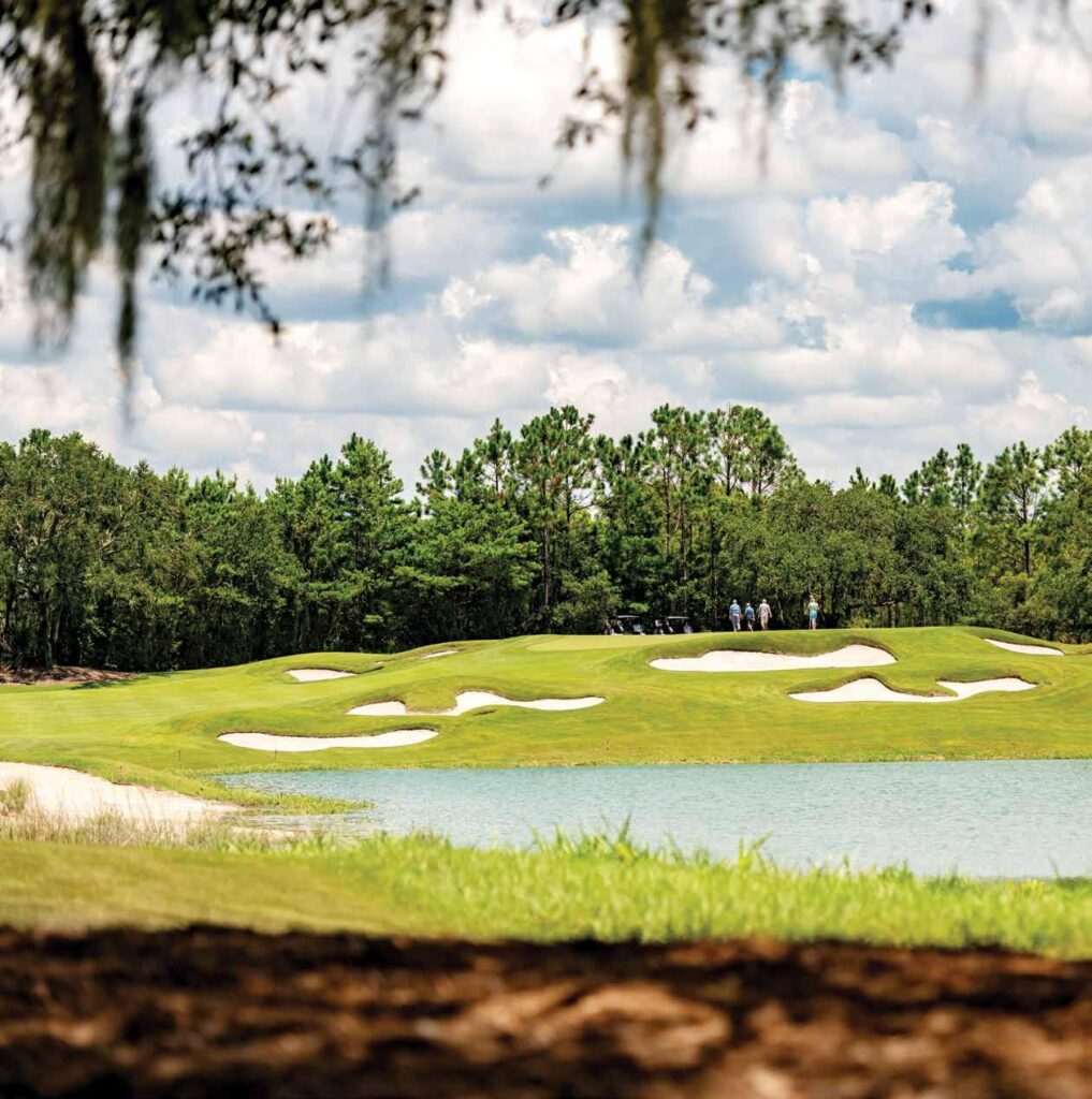 View of several bunkers dotting a green fairway at Camp Creek Golf Course.