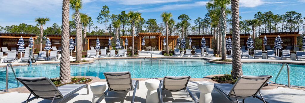 View of the lounge chairs surrounding one of the new pools at Watersound Club amenities by Camp Creek Inn