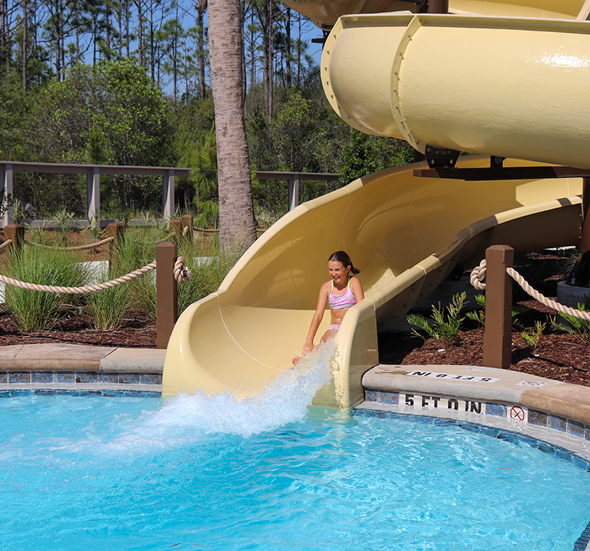 Young Watersound Club Member rushes down the waterslide at the new amenities at Camp Creek