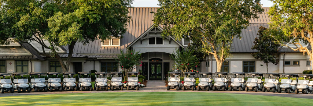 Golf carts lined up in front of the Shark's Tooth clubhouse, ready to get the 2023 Watersound Club Championship started!