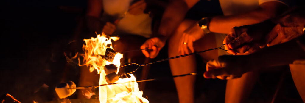 Watersound Club Members enjoying s'mores at a beach bonfire at the Beach Club