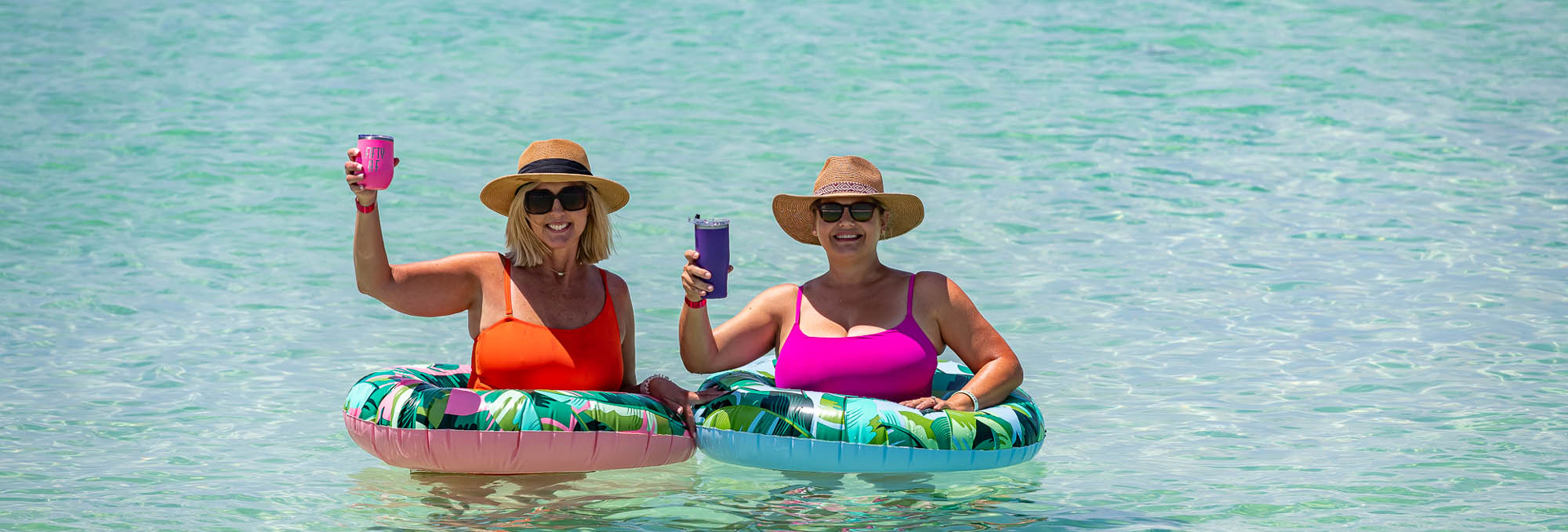 Watersound Club Member ladies enjoying the clear blue gulf waters in bright floats behind the Beach Club