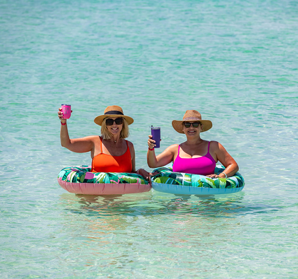 Watersound Club Member ladies enjoying the clear blue gulf waters in bright floats behind the Beach Club